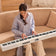 white digital piano being played by woman sitting on sofa in spacious living room