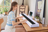 portable light purple digital piano being played at home by woman enjoying music