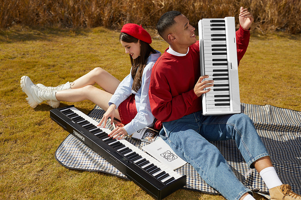 couple enjoying music while playing portable digital piano outdoors