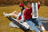 couple enjoying music while playing portable digital piano outdoors