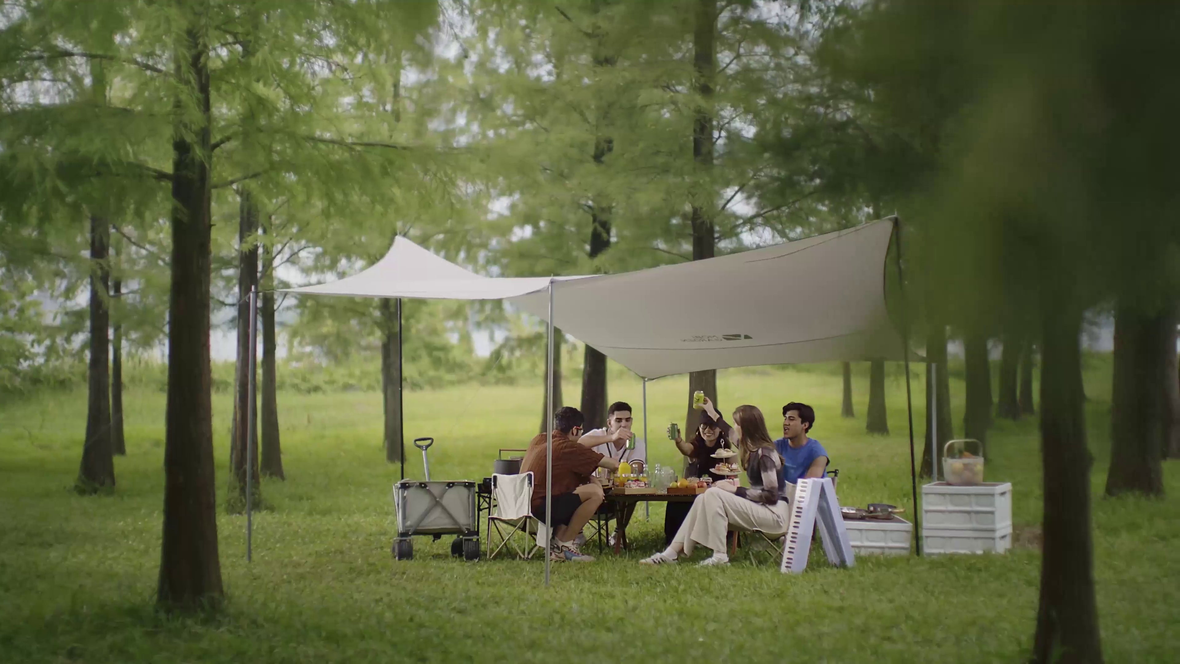 Friends enjoying a forest camping gathering with a folded TERENCE piano
